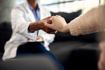 Terapeuta tomando la mano de un paciente en una sesión
